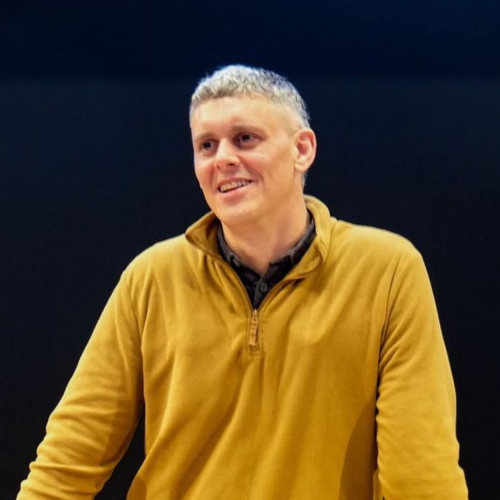 Peter Brewer, founder of Club Coders, smiling, in a mustard quarter-zip jumper